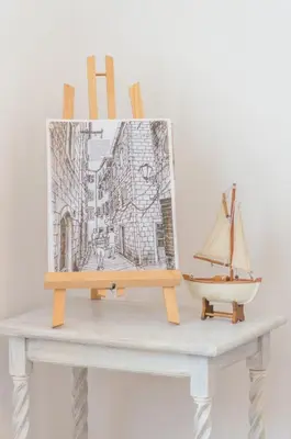 a painting on a table with a boat on it at Central & quiet location inside Old town Kotor in Kotor