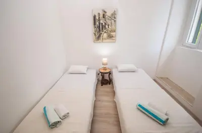 two beds in a small room with a window at Central & quiet location inside Old town Kotor in Kotor