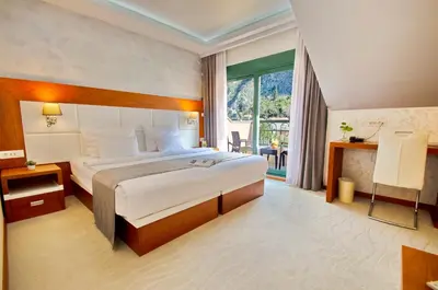 a hotel room with a bed and a large window at Hotel Porto In in Kotor