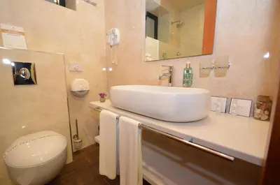 a bathroom with a white sink and a toilet at Hotel Porto In in Kotor