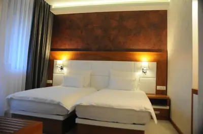a hotel room with two beds with white sheets at Hotel Porto In in Kotor