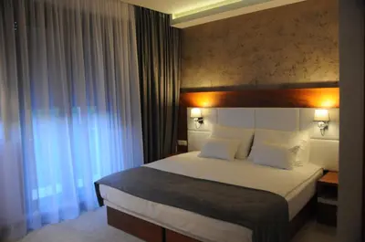 a hotel room with a bed and a window at Hotel Porto In in Kotor