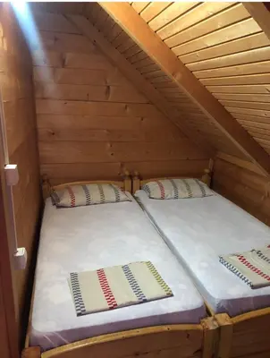 two twin beds in a wooden attic room at Vikendica za odmor in Dobra Voda