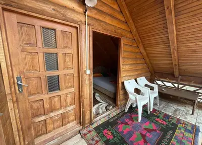 a wooden cabin with two chairs and a door at Vikendica za odmor in Dobra Voda