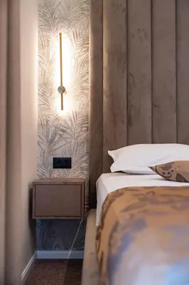 a bedroom with a bed and a light on the wall at LOLA Apartments in Podgorica