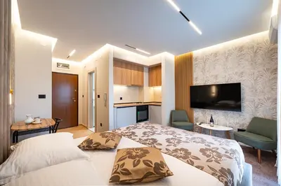 a hotel room with a bed and a kitchen at LOLA Apartments in Podgorica