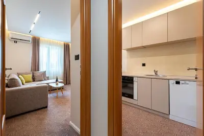a kitchen and a living room with a couch at LOLA Apartments in Podgorica