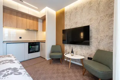a room with a bed a table and a tv at LOLA Apartments in Podgorica