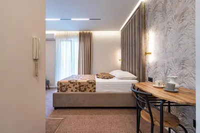 a hotel room with a bed and a table and a desk at LOLA Apartments in Podgorica