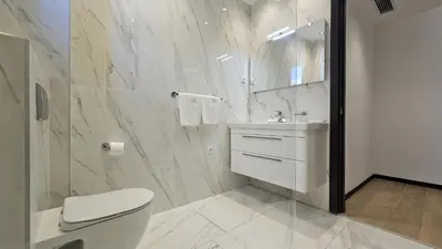 a white bathroom with a toilet and a sink at Azure Corner Residence Budva - Seaside Living Apartments in Becici