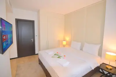 a bedroom with a large white bed with flowers on it at Azure Corner Residence Budva - Seaside Living Apartments in Becici