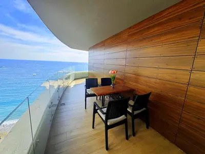 a dining room with a table and chairs and the ocean at Azure Corner Residence Budva - Seaside Living Apartments in Becici