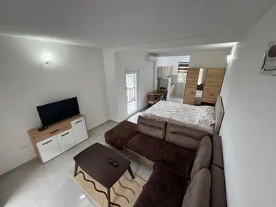 a living room with a couch and a bed at Apartmani in Sutomore