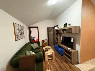 a living room with a green couch and a tv at Gintas Comfort in Podgorica