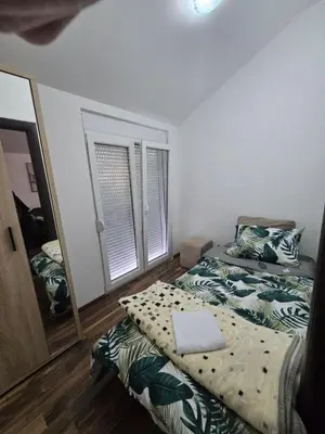 a bedroom with two beds and a mirror at Gintas Comfort in Podgorica