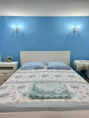a blue bedroom with a bed and two tables at Art House Old Town in Podgorica