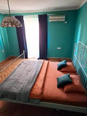 a bedroom with a large bed with blue walls at Art House Old Town in Podgorica