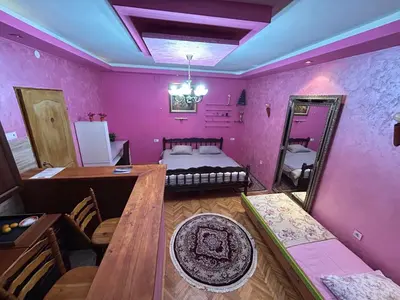 a room with a bed and a table and a mirror at Art House Old Town in Podgorica