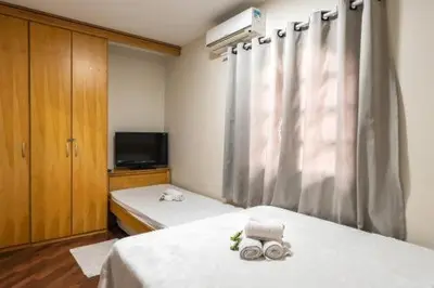 a bedroom with two beds and a window with towels at Art House Old Town in Podgorica