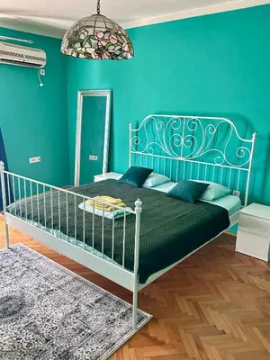 a blue bedroom with a bed and a mirror at Art House Old Town in Podgorica