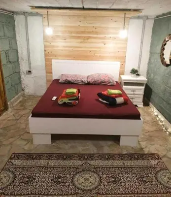 a bedroom with a large bed with red sheets at Art House Old Town in Podgorica