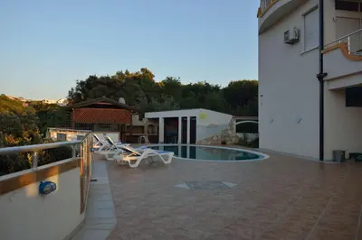 a patio with a swimming pool next to a building at Belvedere Apartments with Seaview in Dobra Voda