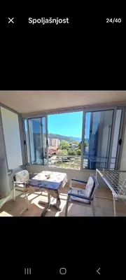 a living room with a table and a bench and a chair at Apartman Tijana in Budva