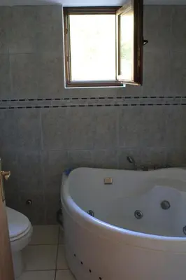 a bathroom with a tub and a toilet and a window at 4M Apartments in Petrovac na Moru