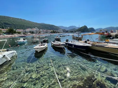 a group of boats are docked in the water at 4M Apartments in Petrovac na Moru