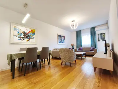 a living room with a table and chairs at Central Point Apartment in Podgorica