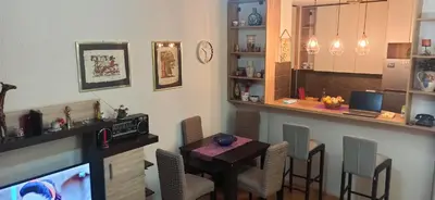 a dining room with a table and a bar at Cozy city center apartment in Podgorica