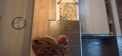 a basket of fruit in a kitchen with a clock at Cozy city center apartment in Podgorica