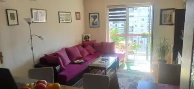 a living room with a purple couch and a table at Cozy city center apartment in Podgorica