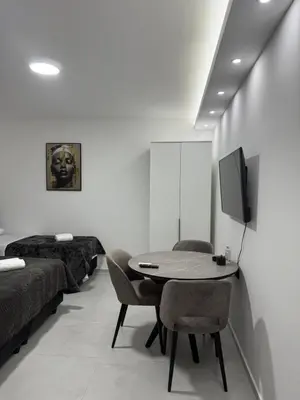 a room with a table and chairs and a tv at Apartmani Zabjelo in Podgorica
