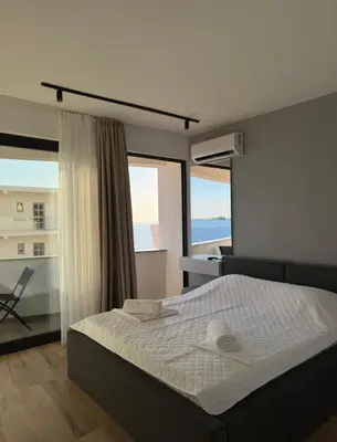 a bedroom with a bed with a view of the ocean at Seaview Komina apartments in Bar