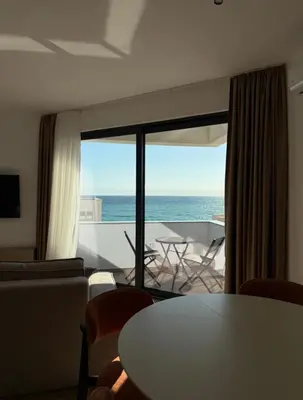 a living room with a table and a view of the ocean at Seaview Komina apartments in Bar