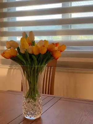 a vase filled with yellow tulips sitting on a table at Braća Velić in Bar