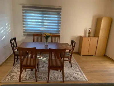 a dining room with a wooden table and chairs at Braća Velić in Bar