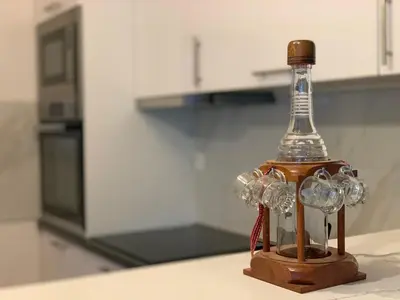 a glass bottle sitting on a table in a kitchen at Braća Velić in Bar