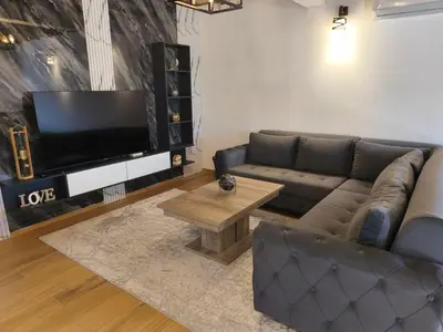 a living room with a couch and a flat screen tv at Braća Velić in Bar