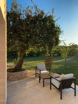 a patio with two chairs and a table and a tree at Braća Velić in Bar