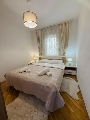 a bedroom with a large bed and a window at Comfort corner Podgorica in Podgorica