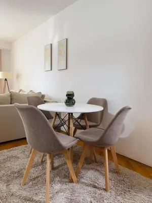 a table and chairs in a living room with a couch at Comfort corner Podgorica in Podgorica