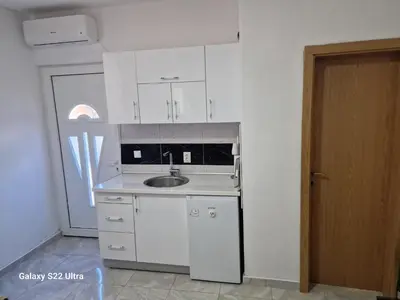 a kitchen with white cabinets and a sink at Apartmani Kruče in Ulcinj