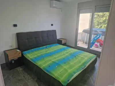 a bedroom with a bed with a colorful blanket on it at Apartmani Kruče in Ulcinj