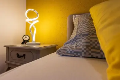 a bedroom with a bed with a mirror on a nightstand at Apartment Mia in Podgorica