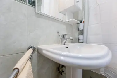 a bathroom with a white sink and a mirror at Apartment Mia in Podgorica