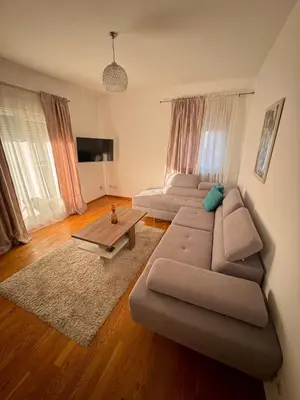a living room with a couch and a table at Bright & Modern Apartment in City Kvart in Podgorica