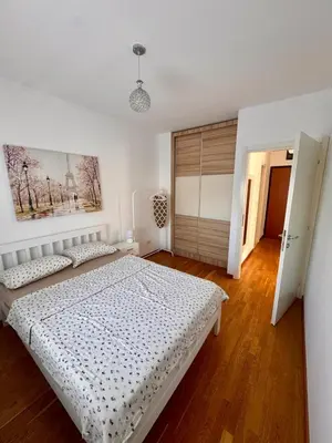 a white bedroom with a bed and a window at Bright & Modern Apartment in City Kvart in Podgorica