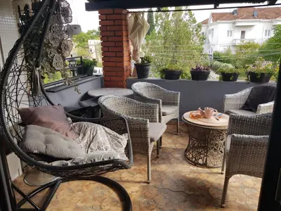 a patio with chairs and a table and a swing at Katata Apartment in Podgorica